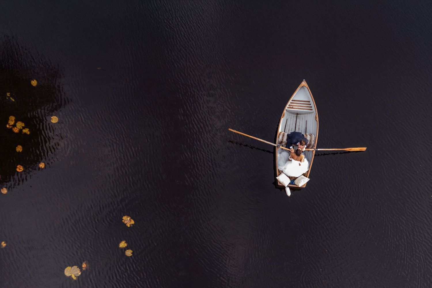 Bride and Groom kiss on a rowing boat - photographed from above with a drone