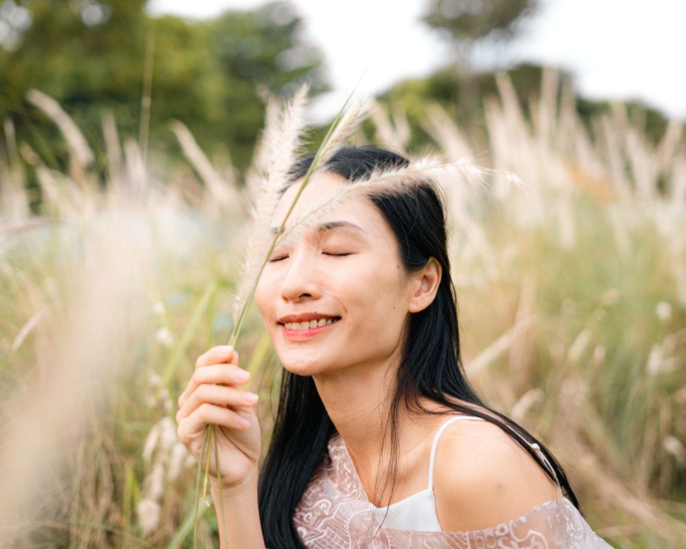 Joyful moment captured among swaying pampas grass in pink lace outfit.