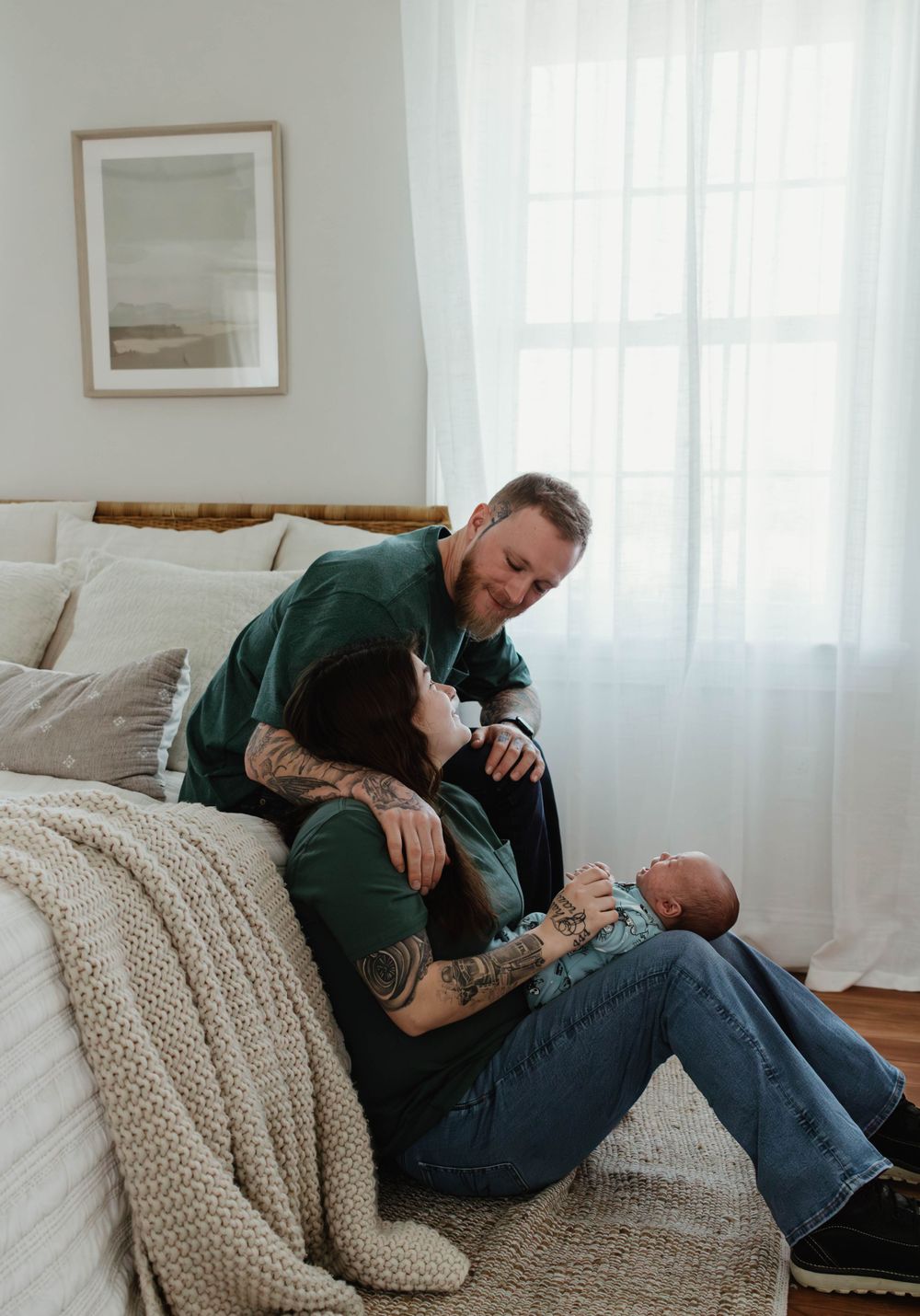 Family spends quality time together on white couch next to bright window.