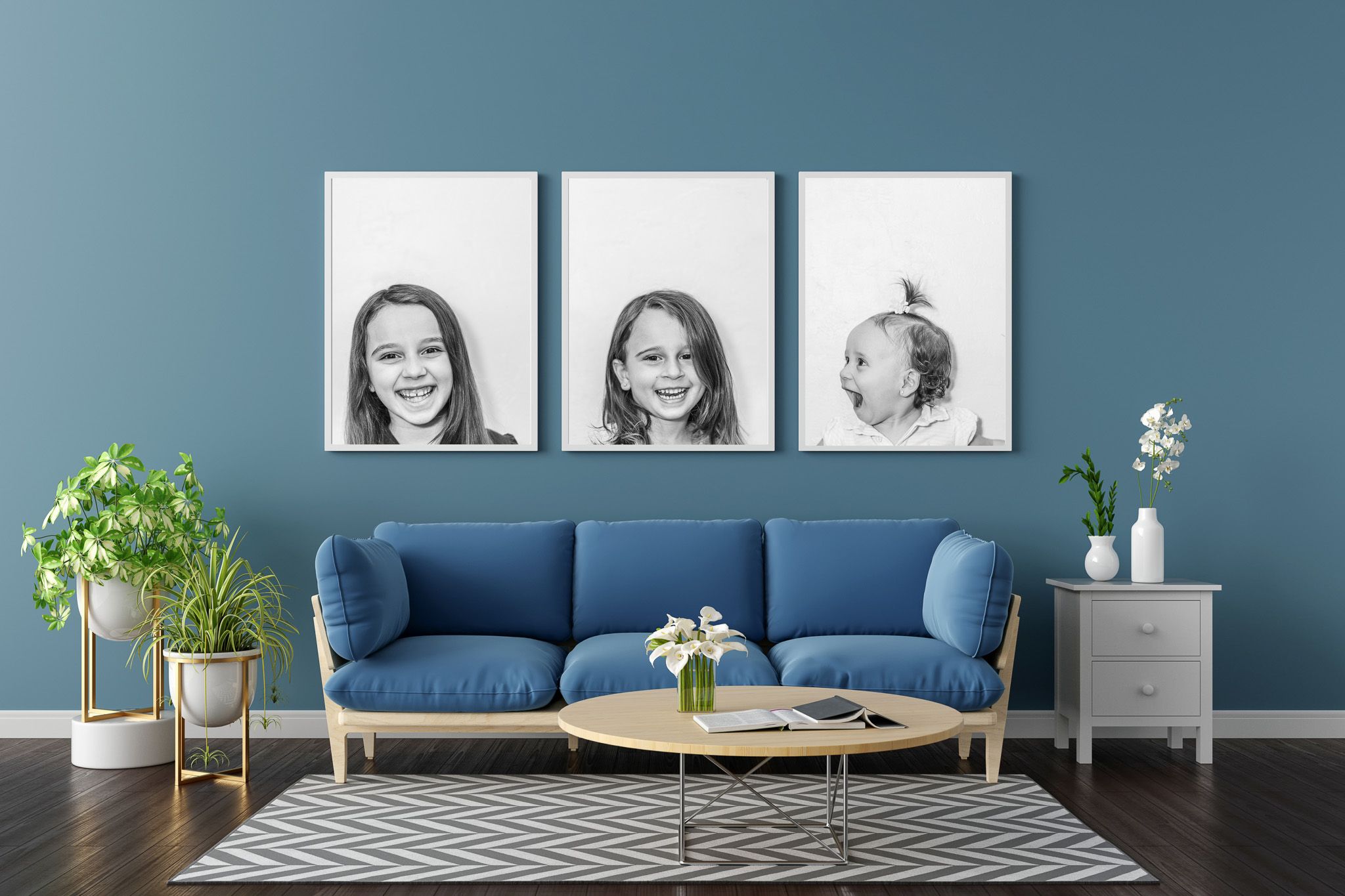 Modern living room interior with blue walls, navy sofa, black and white rug, and three framed portrait photos above couch.