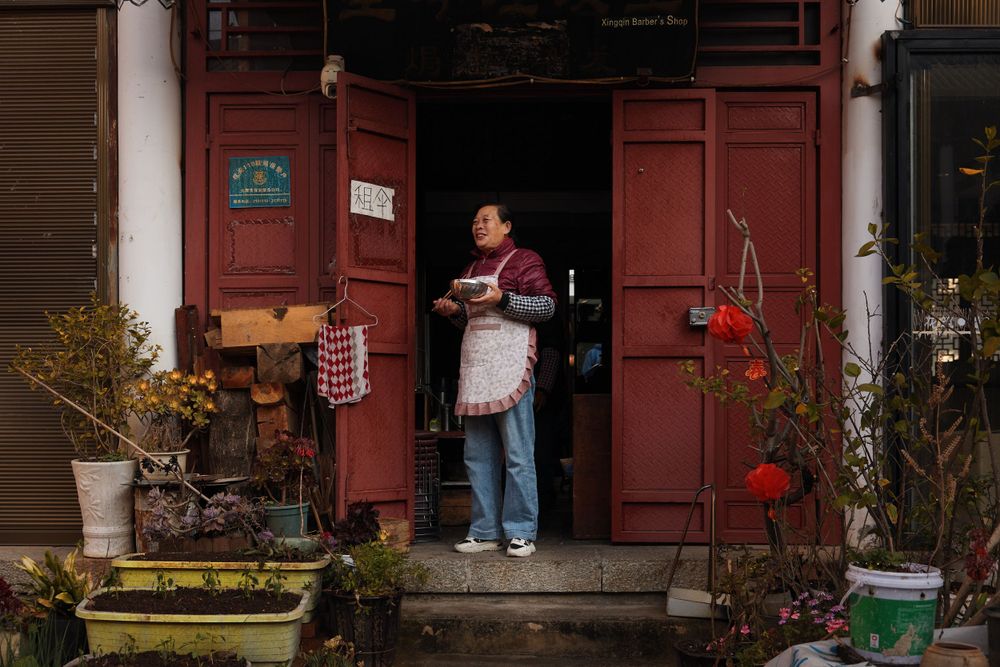 Traditional red doorway entrance decorated with Chinese New Year ornaments and potted plants.