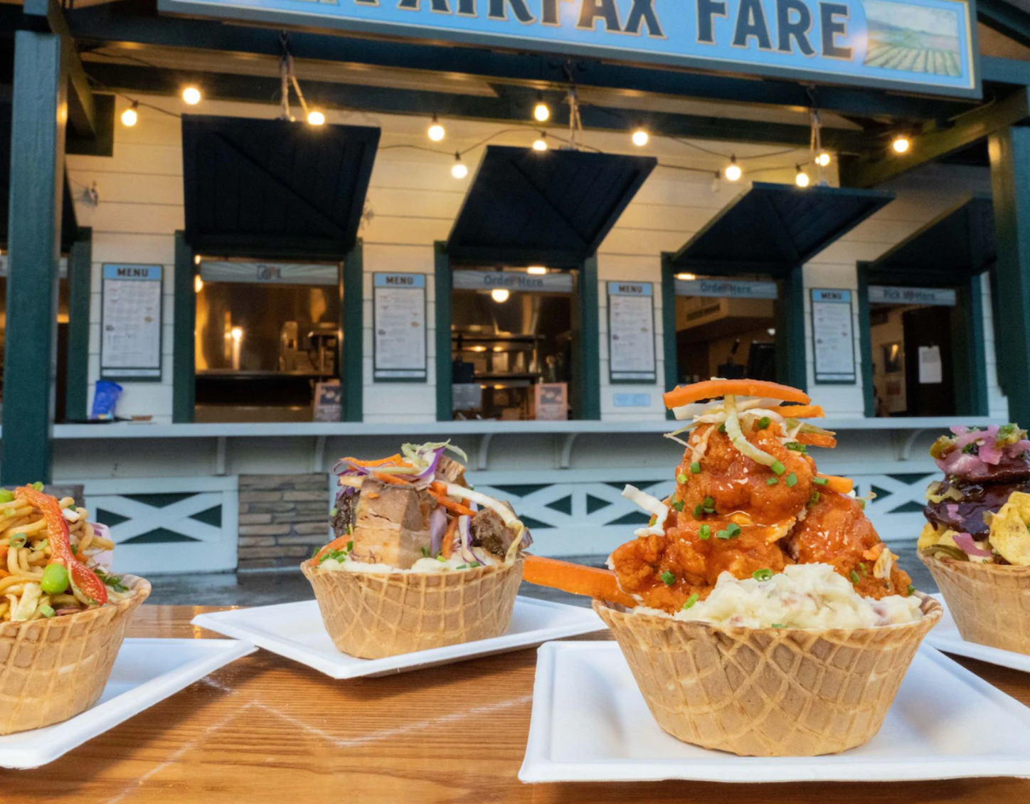Row of artisanal dishes served in waffle cone bowls at Fairfax Fare restaurant counter.