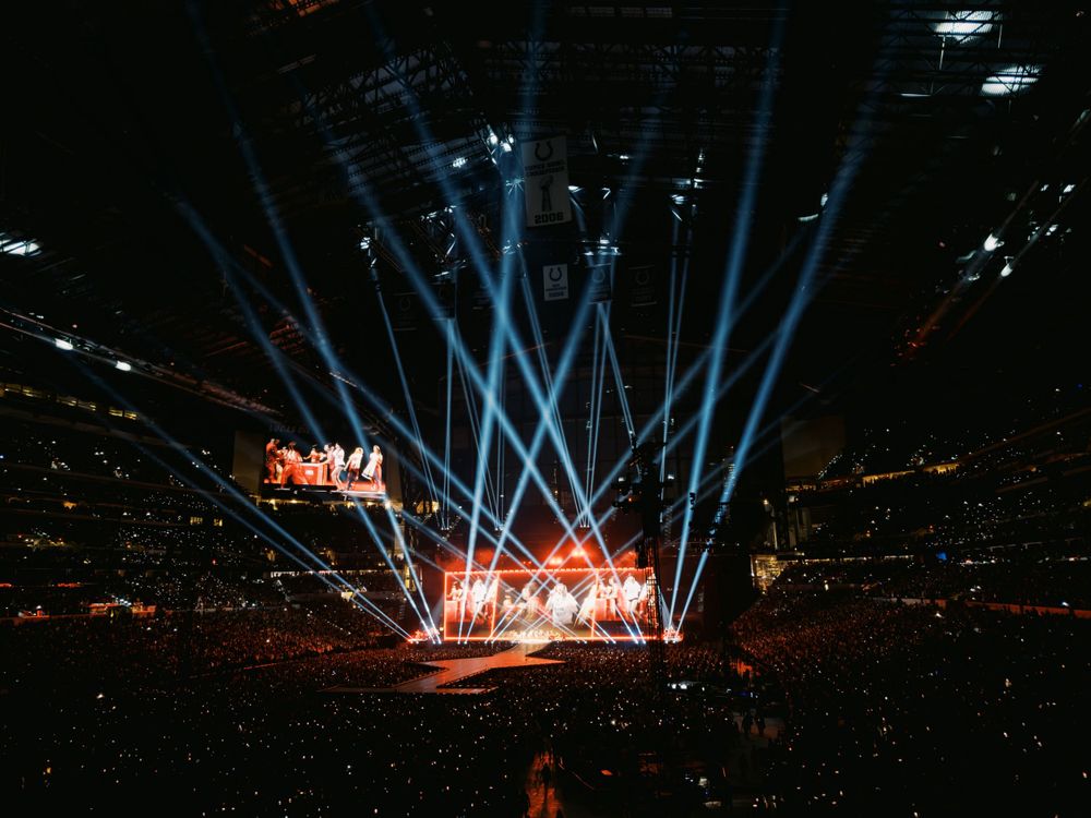 Stadium concert stage illuminated with dramatic blue lighting effects.