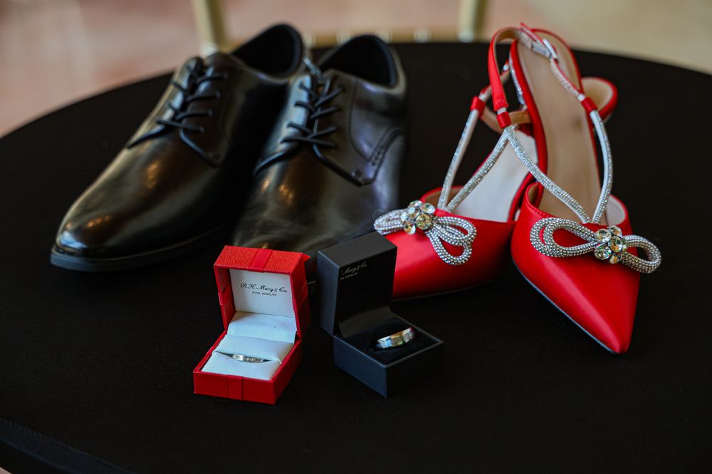 Collection of formal shoes including red and black heels arranged on dark surface.