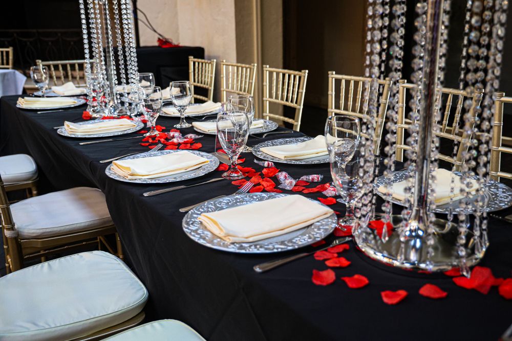 Formal table setting with crystal centerpieces and red accents for special event.