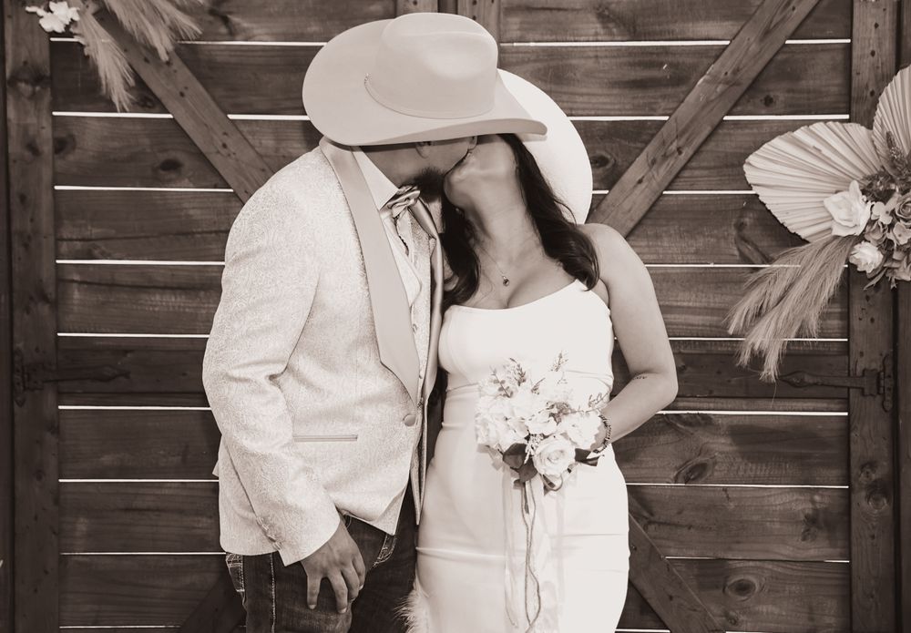 Black and white wedding photo collage showing romantic moments between newlyweds against a rustic wooden wall background.