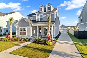 Coastal style gray two-story home with white trim and landscaped front yard.