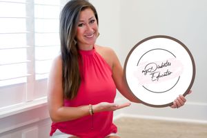 Woman in bright pink dress holding decorative plates in a white interior space.