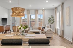 Modern living room with woven pendant lights, beige sectional and hardwood floors.