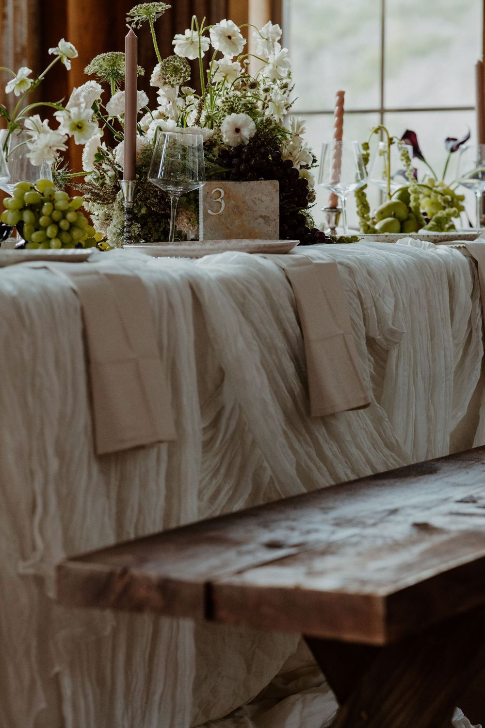 Elegant wedding table setting with white linens and delicate floral centerpieces.