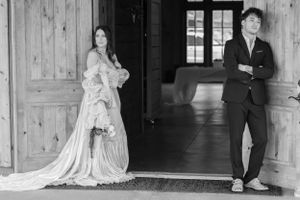 Wedding party poses in rustic wooden doorway of barn venue in North Georgia.