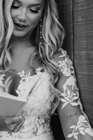 Close-up of bridal gown with lace sleeves in black and white.