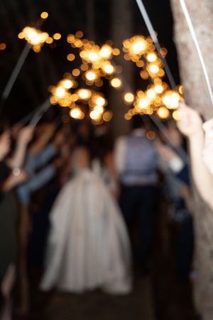 Blurred sparkler exit scene with golden bokeh lights creating a dreamy night atmosphere.