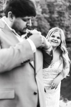 Black and white candid wedding moment with couple sharing joyful laughter.