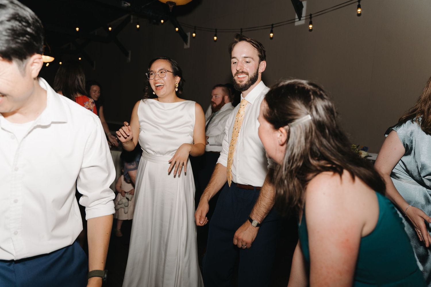 Wedding guests enjoying themselves on the dance floor during a celebration.