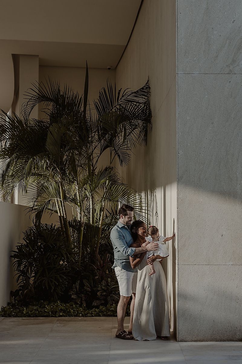 Family portrait at The St. Regis Kanai Resort, parents holding daughter during Riviera Maya vacation photoshoot.