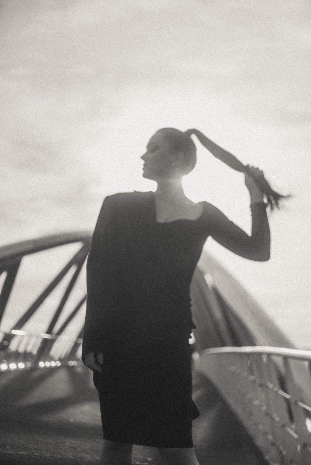 Silhouetted figure against bright sky on architectural structure.