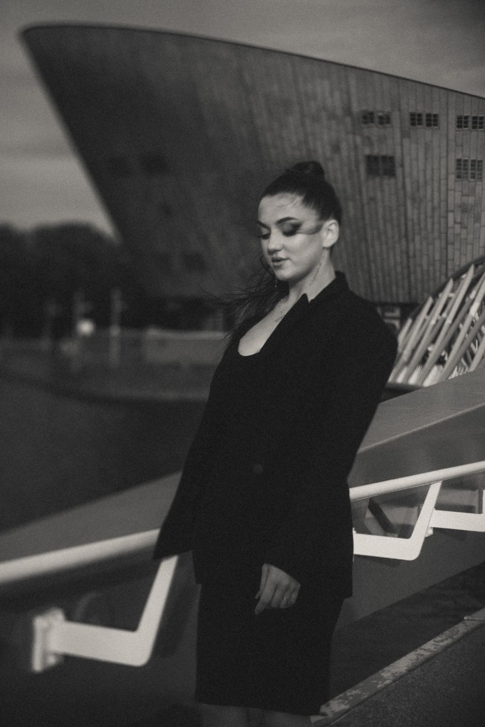 Artistic black and white photo of someone seated in contemplative pose.