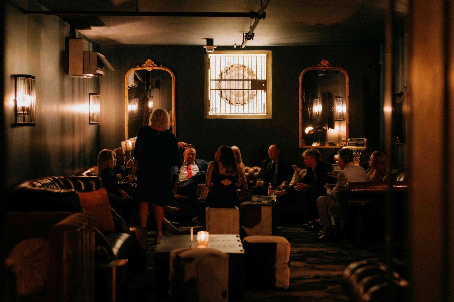 A group of family members during cocktail hour at a wedding hanging out in an intimate venue space.