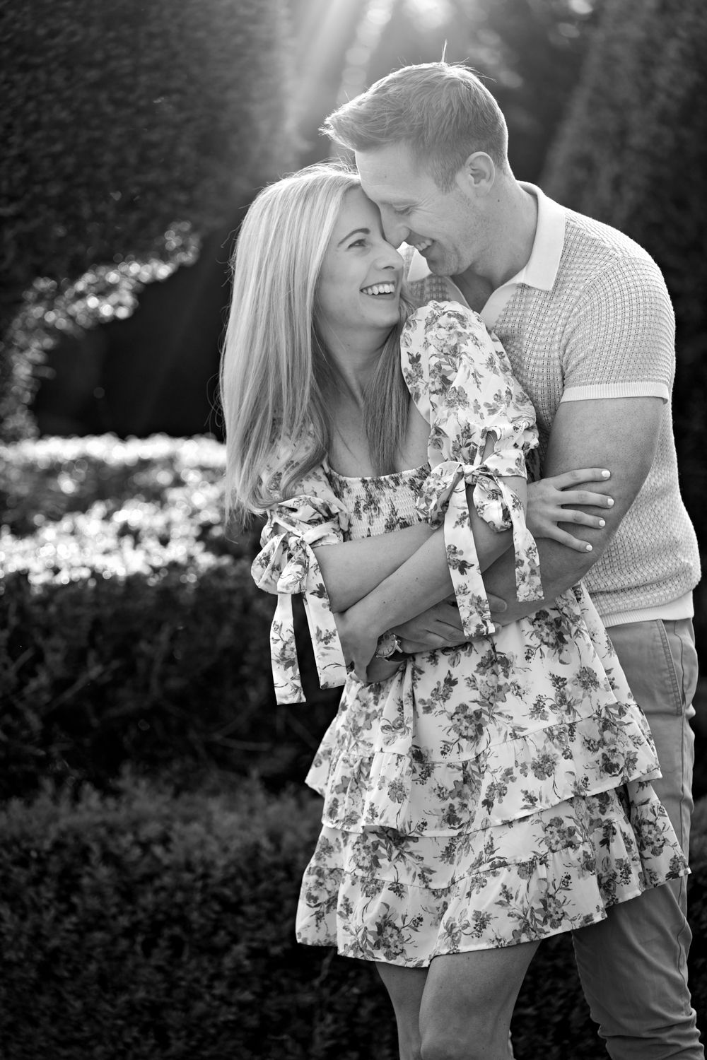 A joyful piggyback ride in a sunlit field during golden hour, captured in black and white.