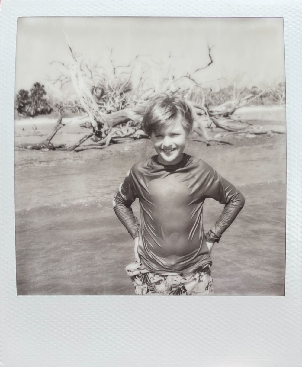 A sequence of black and white photographs showing someone in casual attire posing in an arid desert landscape.