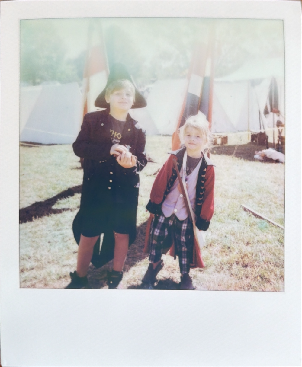 Two people enjoying time together outdoors on a sunny day, captured in a vintage-style photograph.