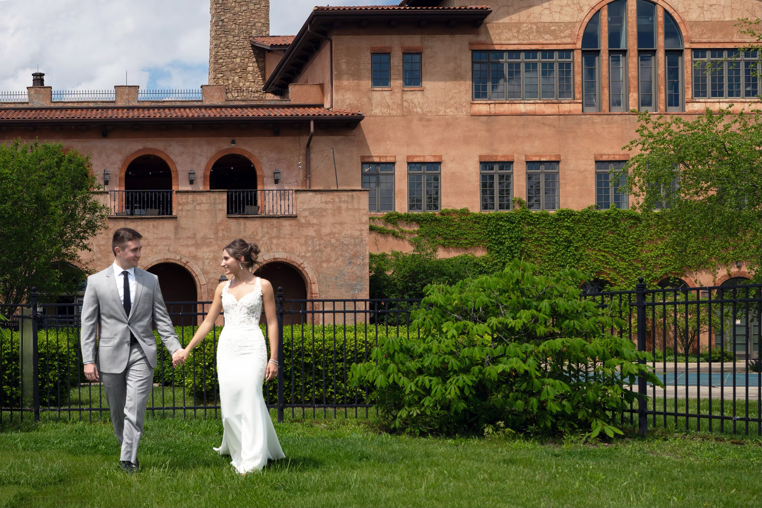 A couple in wedding attire walks together across the club at corazon