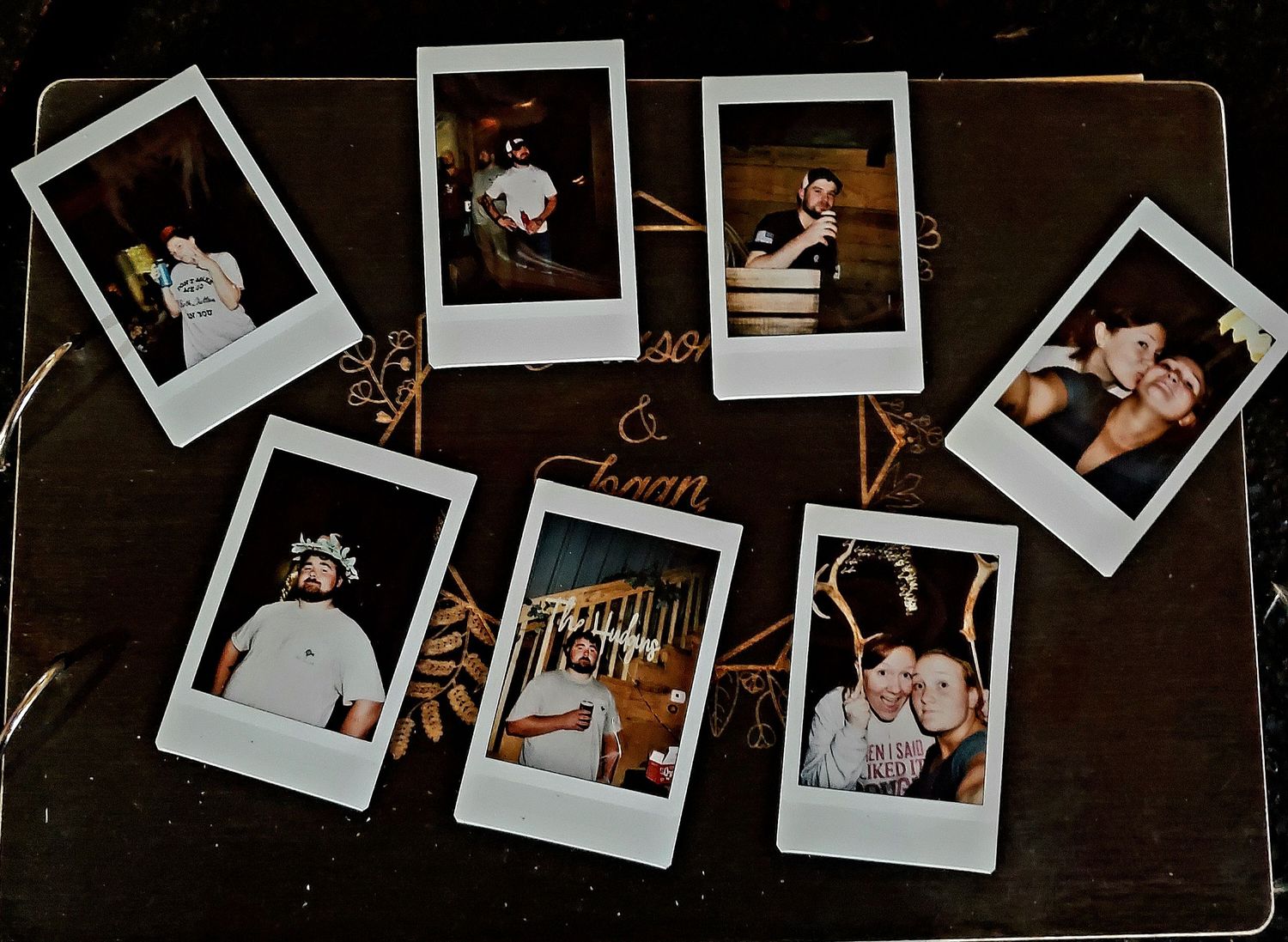 Collection of vintage Polaroid instant photographs scattered on a dark wooden surface showing wedding moments and details.