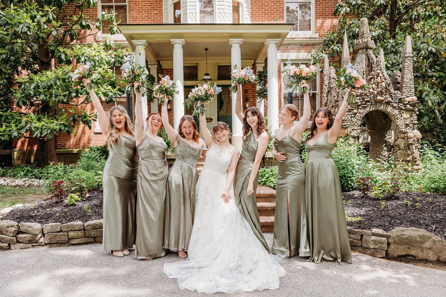 Joyful and excited bride with her bridesmaids. Green bridesmaid dresses at The Inn at Oneonta in Northern Kentucky.