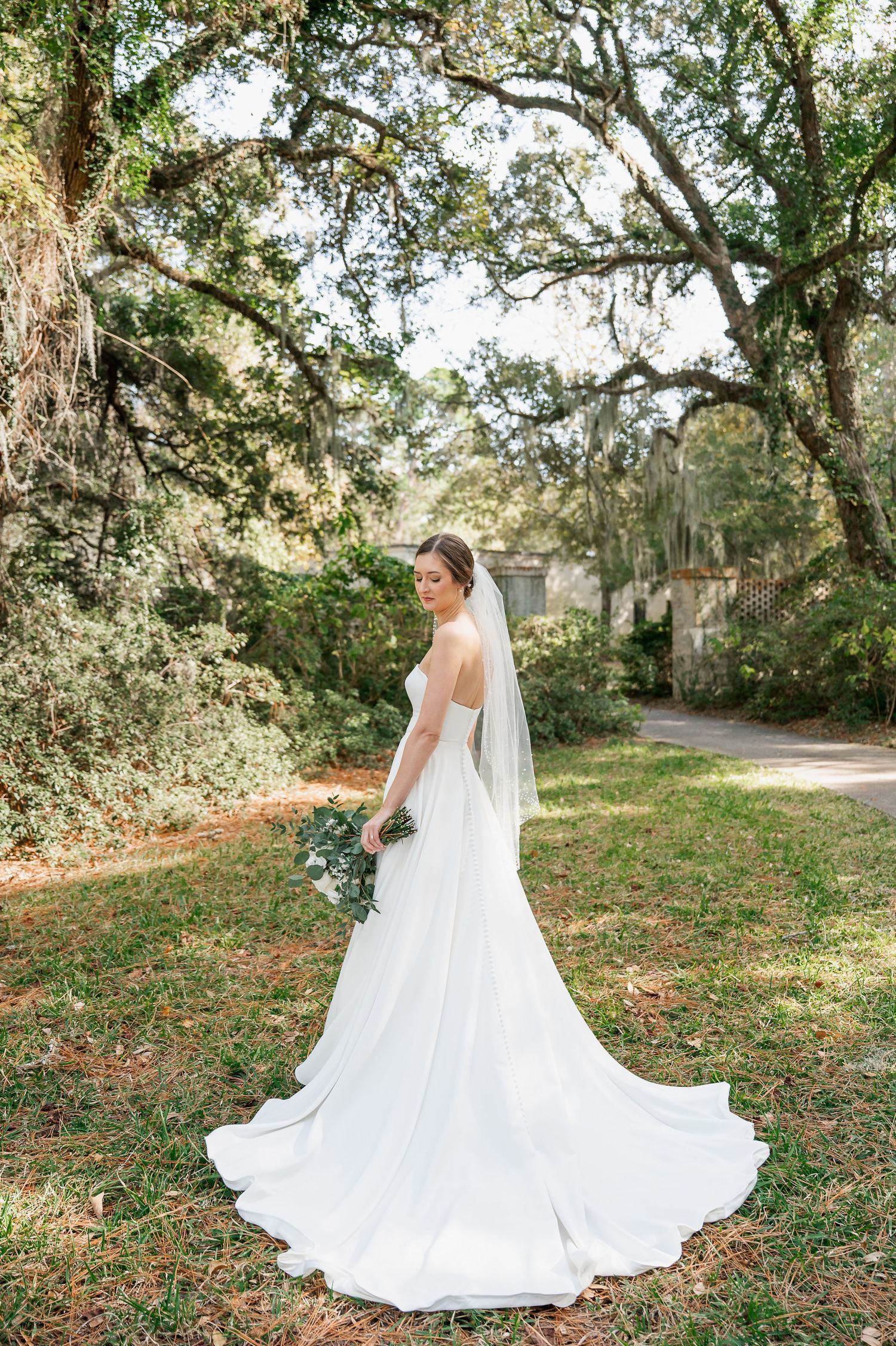 Bride's dramatic cathedral-length train spreads beautifully across garden grounds.