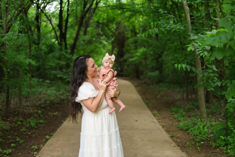 A couple walks along a tree-lined path in a lush green forest during summer.