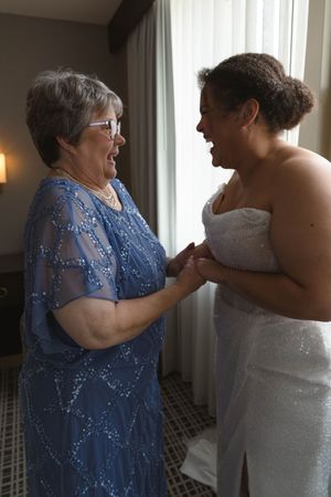 Two people sharing an emotional moment in formal blue and white dresses.