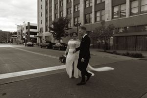 A couple walking together on a city street in black and white photography.