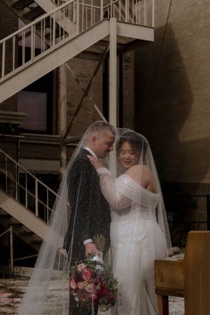 A tender wedding moment photographed against an industrial staircase backdrop.