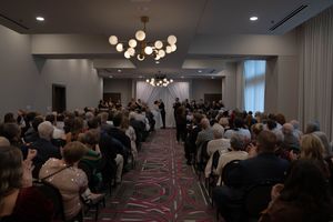 Panoramic shot of a packed conference hall with elegant lighting and contemporary design.