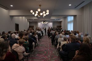 Full room of attendees seated in rows at an indoor ceremony or presentation.