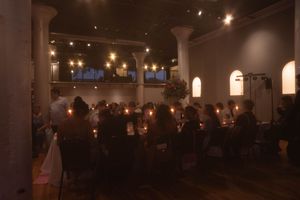 Dimly lit event space with ambient lighting and architectural columns.
