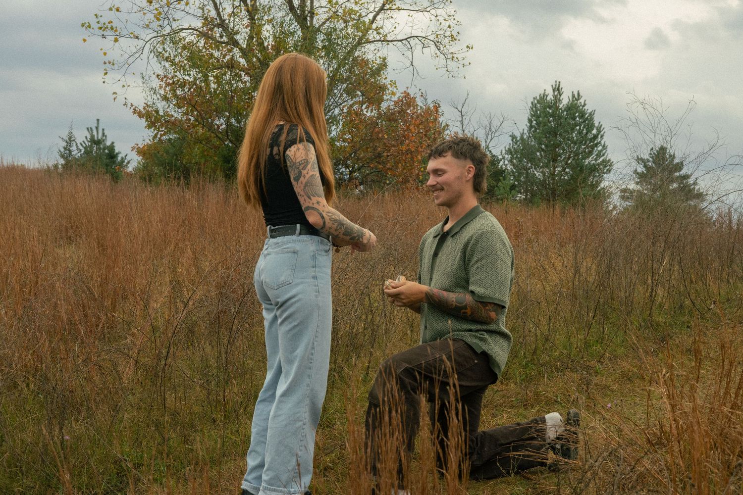 A couple laughs and smiles after the man has just proposed to the woman. A secret photographer has just captured the moment.