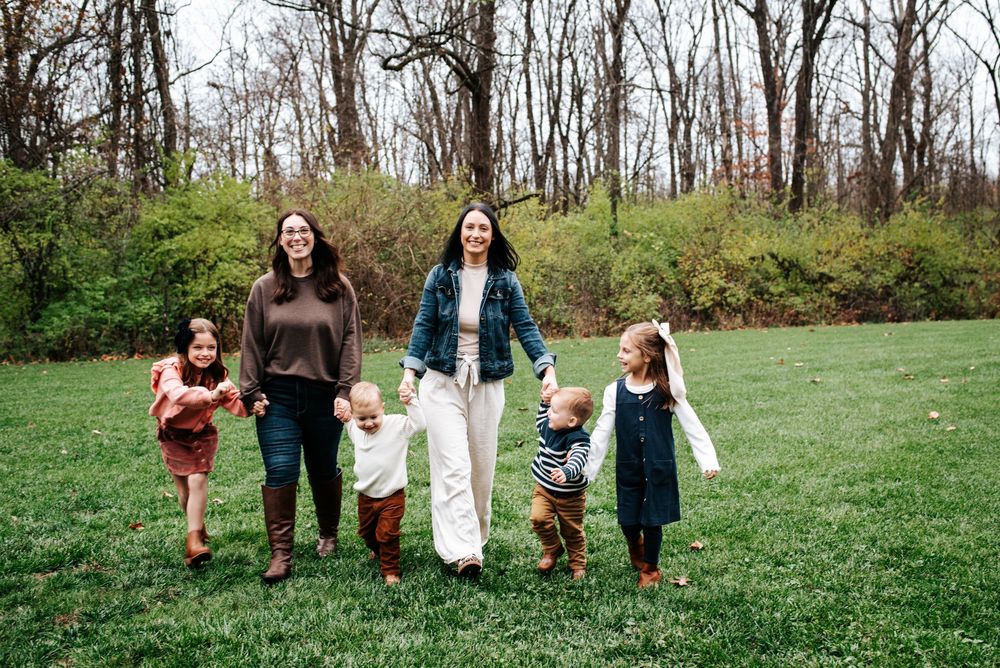 Group walking together across green field on spring day.