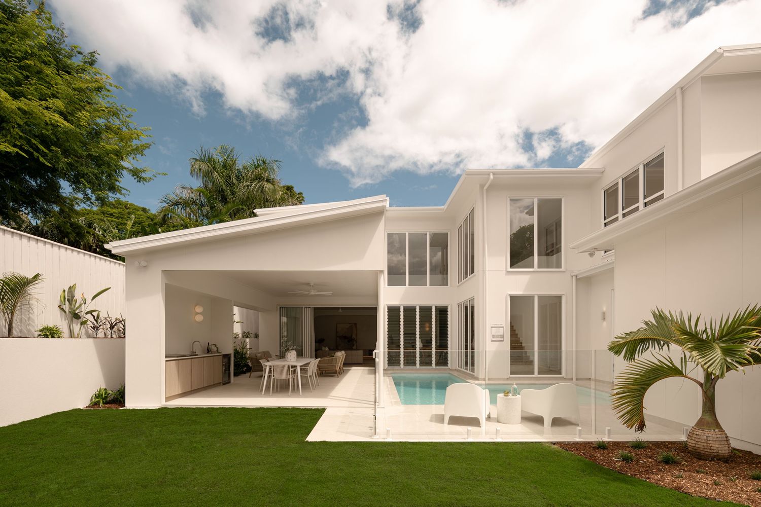 Modern white mid-century home with floor-to-ceiling windows and pool features clean lines and minimalist architecture.