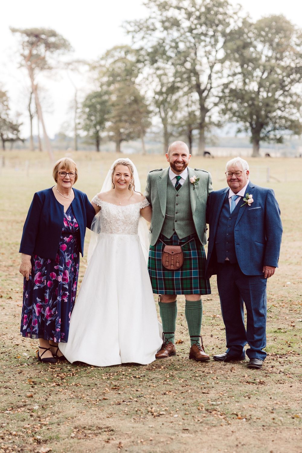 A creative wedding photo series showing a group lined up outdoors with their legs cropped out of frame.