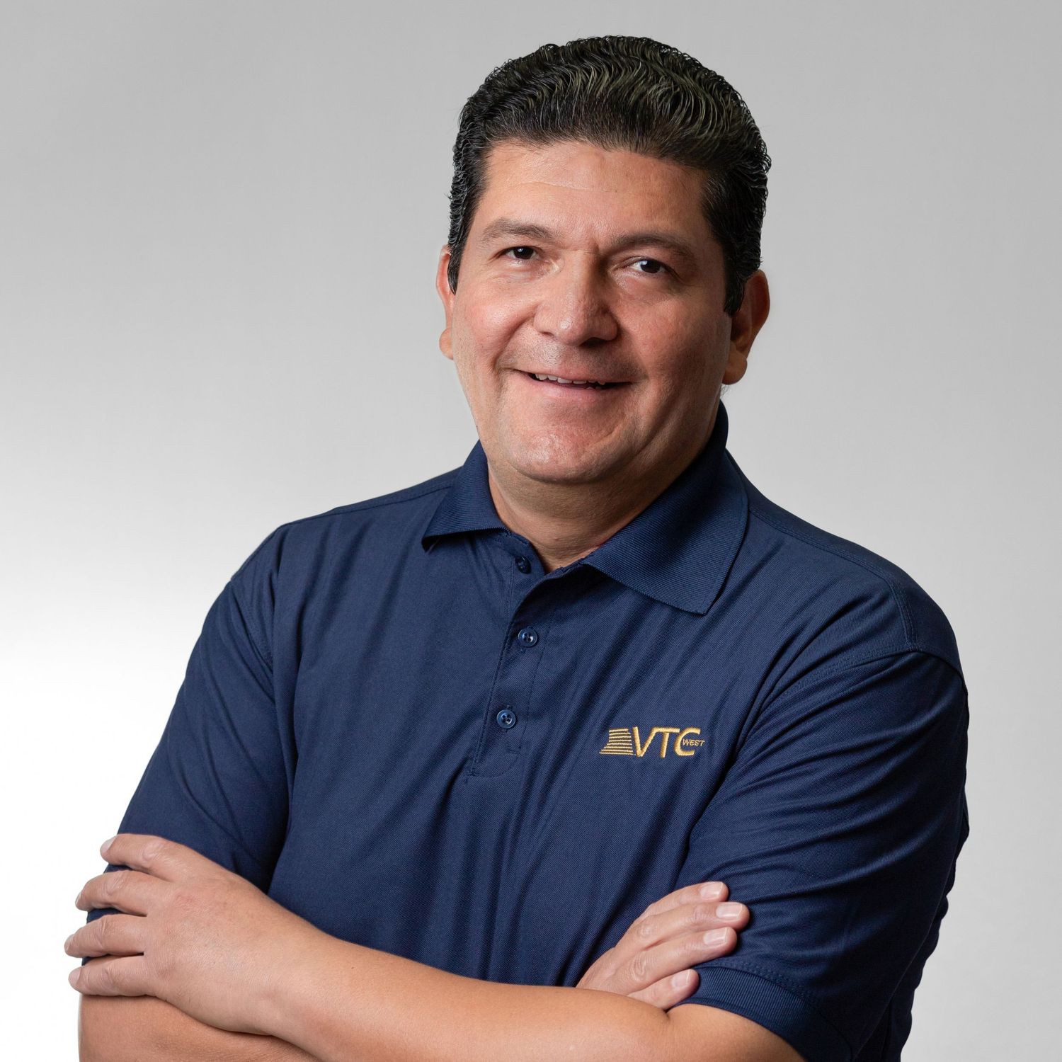 Person wearing navy blue polo shirt with company logo in casual business portraits.