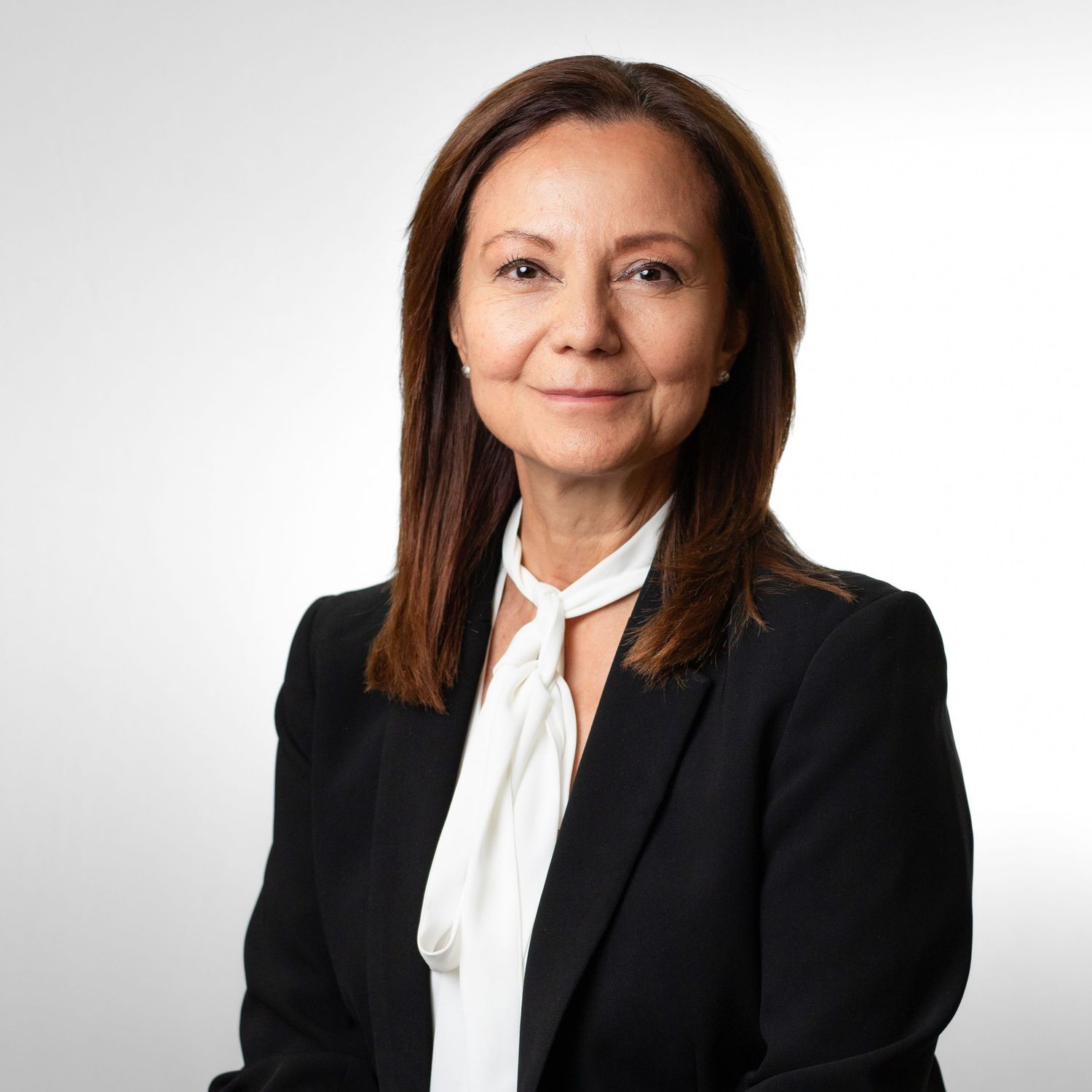 Professional headshots of someone in a black blazer and white blouse against a light background.