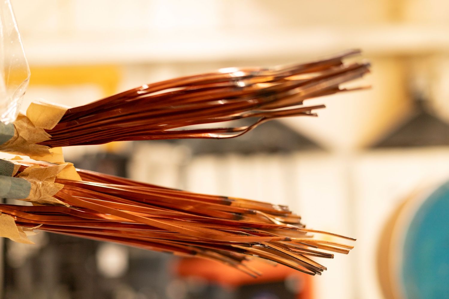 Close-up view of bundled copper wires with warm lighting highlighting their metallic sheen.