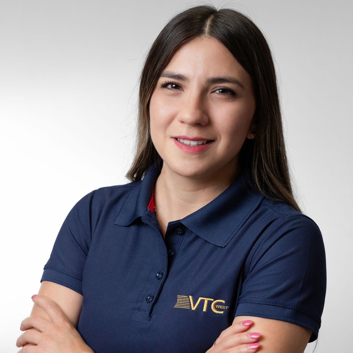 Professional portrait of someone wearing a navy blue polo shirt with VTC logo against a light gray background.