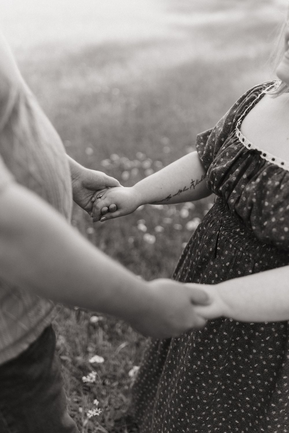A series of black and white images showing hands gently reaching out to touch a polka dot dress in a field.