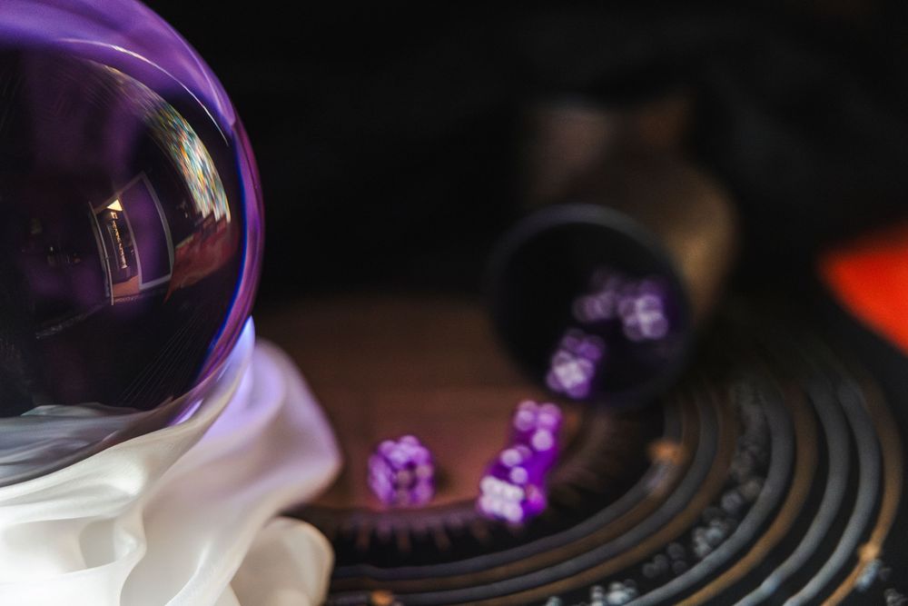 A row of vinyl records illuminated by purple lighting creates a moody atmospheric display on a dark surface.