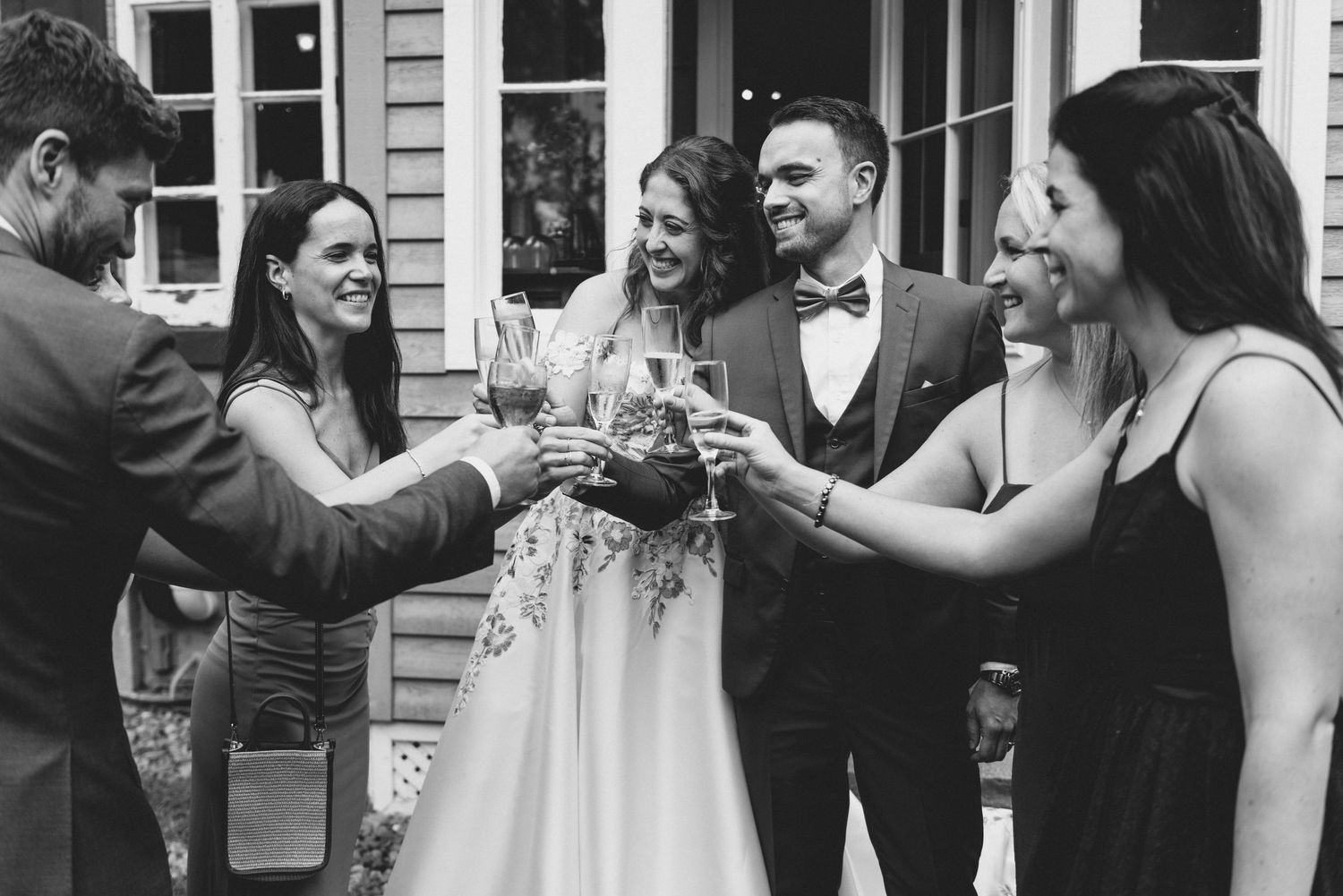 Black and white photos showing joyful celebration moments at an outdoor wedding reception.