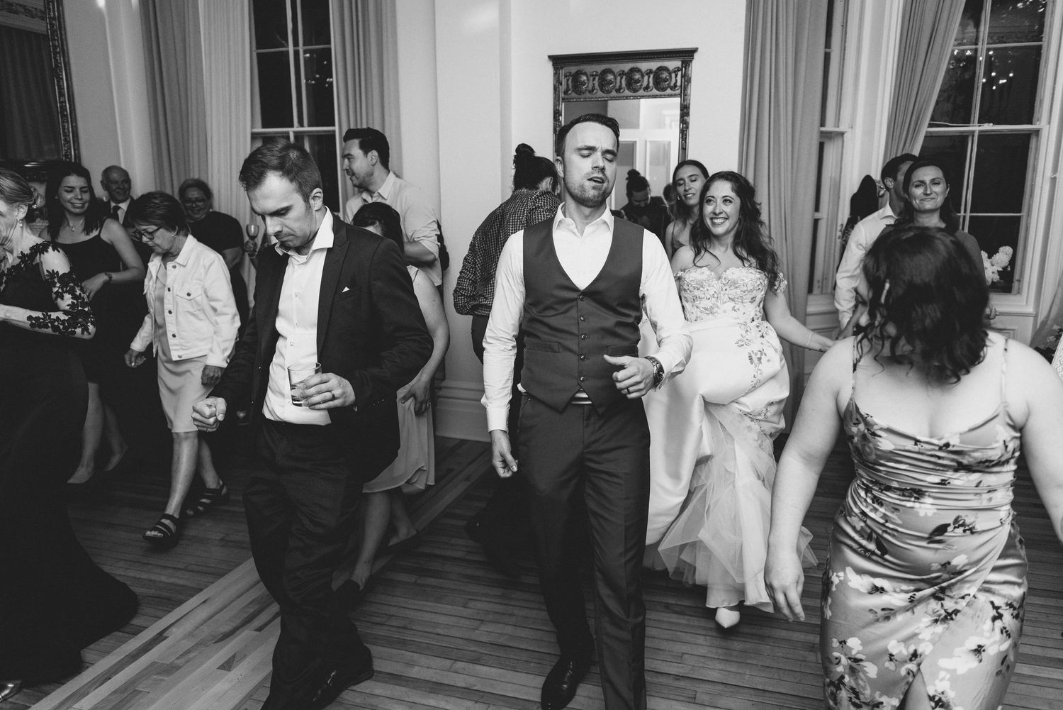 Dancers move energetically across a wooden dance floor during a lively social dance event.