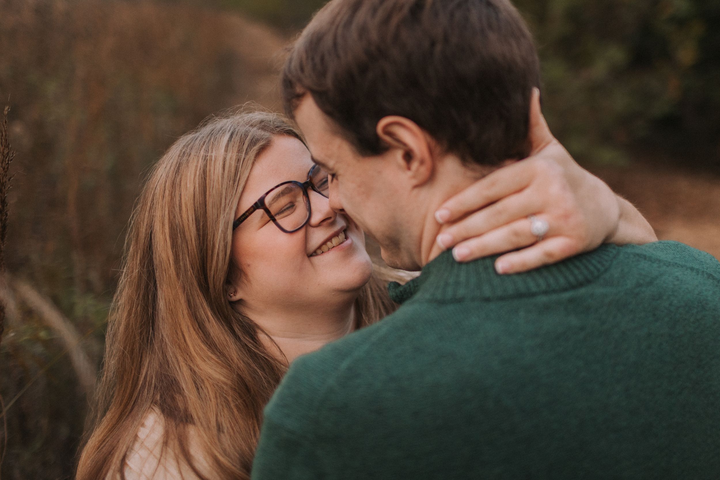 A couple embraces and laughs together during an outdoor photo session.